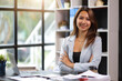 © Wasan - Portrait of a charming business woman happy at her desk in the office.