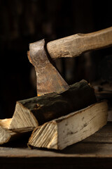 An ax is cut into a log of firewood for a firebox on a wooden texture