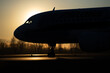 Airliner on runway ready to take off at sunset backlight - concept of air transport and travel