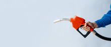 Person Holding A Gas Nozzle On A White Background, Fuel Consumption, Petrol-fueled Cars, Fluctuating Oil Prices, Using Alternative Fuels For Driving.