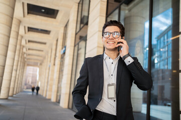 Wall Mural - Talking on the phone. Confident businessman man with glasses in a business suit