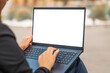 © ARVD73 - Blank white screen.Mockup.Young brunette business woman use laptop computer outdoor cafe.She dressed in black suit spending her lunch time at street cafe terrace.Close-up.Selective focus.