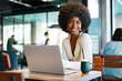 © fotofabrika - Smiling young african woman sitting with laptop in cafe
