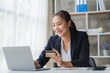 © Kritdanai - Happy asian Business woman pay online using mobile phone at the office.