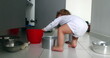 © Marco - Baby getting up from the kitchen floor. Baby playing with kitchen utilities, opening closet. Toddler at play with pots and pans