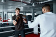 Two sparring partners in boxing gloves practice kicks