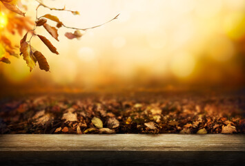 Wall Mural - An autumn golden sunset background of tree leaves and trees in the fall with a wooden nemch, table, to display products on.