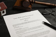 © New Africa - Last will and testament near house model, glasses, gavel on black table, closeup