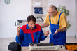 © Elnur - Two male repairmen repairing air-conditioner
