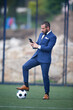 © Imaxepress - businessman with a ball on his foot chatting with the smartphone inside a soccer field