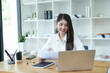 © maeching - Asian business woman Use a laptop computer and work at the office ready. plan to analyze financial reports