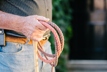 old retired cowboy holding a whip