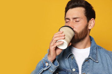 Wall Mural - Bearded man drinking coffee on orange background. Space for text