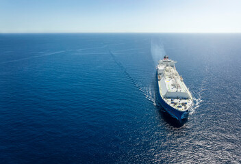 Wall Mural - High aerial view of a large LNG or liquid gas tanker ship traveling over blue ocean, with copy space