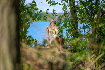 Blond woman posing on a tree trunk