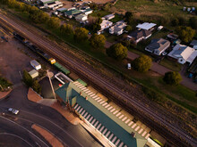 Engine Of Freight Train Passing Station Seen From Above In Late Evening