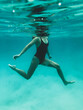 © Austockphoto - Mature woman's athletic body treading water from underwater perspective in ocean