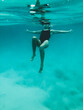 © Austockphoto - Mature woman's athletic body treading water from underwater perspective in ocean