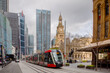 © Austockphoto - Light rail in front of Town Hall in Sydney on overcast day