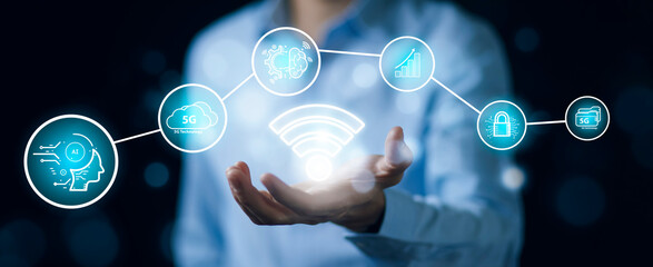 Businessman hold Wifi with Artificial Intelligence (AI),on big data network machine learning and data on the dark background, artificial intelligence technology, innovation and futuristic.