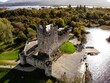 Aerial shot of the Ross Castle in Ireland with lush trees in the background