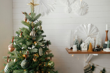christmas tree with vintage baubles and little christmas village decoration. modern christmas tree a