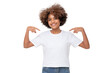 © Damir Khabirov - Smiling african girl pointing at her blank white t-shirt with both index fingers, copy space for your logo, isolated