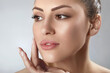 © verona_studio - .Beautiful smiling young woman with shiny glowing perfect facial skin and bare shoulder looking aside beauty studio portrait copy space. Cosmetology, dermatology