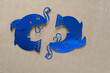 silhouette of blue foil fish on plain brown corrugated paper