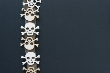 Wall Mural - jolly rogers or skull and crossbones arranged on a piece of dried bark with blank space (vertical arrangement)