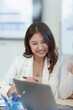 © amnaj - Charming, beautiful and confident Asian businesswoman is smiling and enjoying working on new idea using a laptop to work at the office.