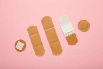 Wall Mural - Beige adhesive bandages on pink background. Medical plasters