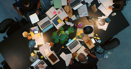 Wall Mural - Marketing and advertising team planning in a meeting at night from above in an office. Company workers discuss with documents in a strategy teamwork, analytics progress and analysis in corporate work