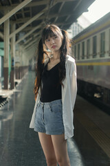 Wall Mural - Portrait of thai japan adult beautiful girl white shirt blue jeans relax time, train station fashion