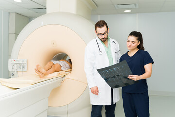 Wall Mural - Technician and nurse looking at the resonance results of a patient at the laboratory