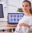 © shefkate - Young woman working in office, sitting at desk