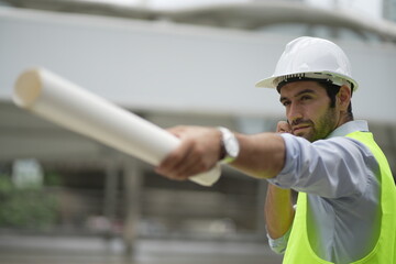 Architect or engineer with blueprints. Cauacsian Engineer checking plan on construction site. modern structure.