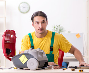 Wall Mural - Man repairman repairing vacuum cleaner