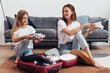 Mother and daughter going on trip pack suitcase