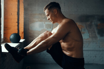 Wall Mural - Handsome muscular man holding hands on hip while standing in gym