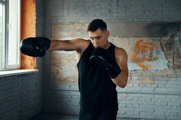 Sticker - Confident young man practicing in punching while standing in gym