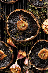 Wall Mural - Grilled portobello mushrooms with thyme and garlic on a grill plate, close up view