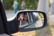 Leinwandbild Motiv a woman takes a picture of herself in the car mirror