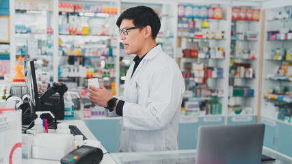 male pharmacist at drugstore.Doctors specializing in medicines.Medical product inventory.male doctor holding a prescription.Health care pharmacists work at the hospital.