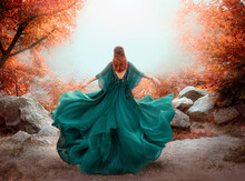 Fantasy Woman Queen Red Hair Runs In Autumn Forest. Girl In Long Elegant Royal Evening Vintage Green Dress. Silk Fabric Skirt Flying Fluttering In Wind. Orange Tree. Art Photo Bare Open Back No Face 