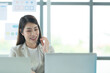 Young asian woman working at a call center Consulting about stock investment information with customers calling for advice