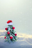 Fototapeta Kuchnia - Christmas tree with red Santa hat on white snow.