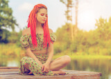 Fototapeta Abstrakcje - Beautiful woman on wooden pier at side of pond