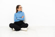 © luismolinero - Young Caucasian woman sitting on the floor happy and smiling