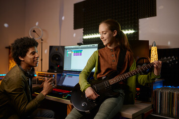 Wall Mural - Music producer and teenager girl guitarist at recording studio